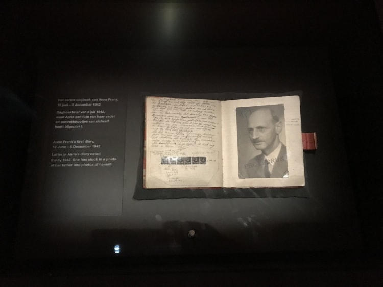 Het eerste dagboek van Anne Frank met aan de rechterkant een foto van haar vader.